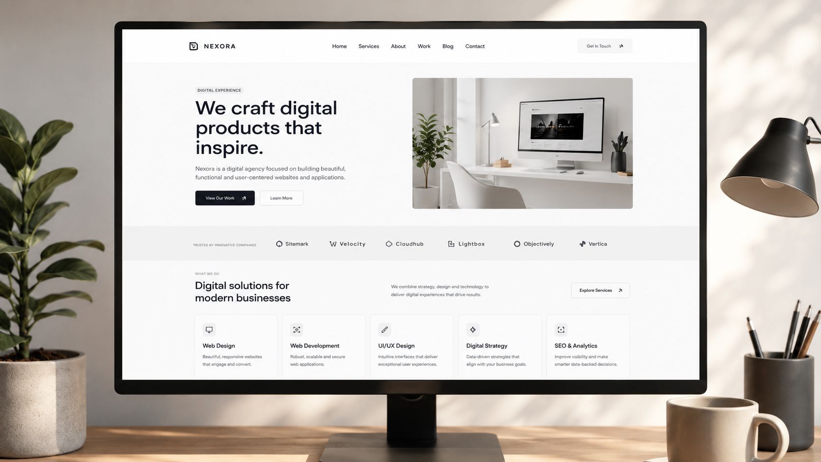 A modern website landing page for a digital agency named Nexora displayed on a computer monitor screen.